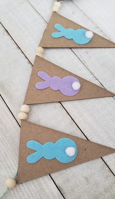 three little buntings with blue and purple felt fish on them sitting on a wooden floor