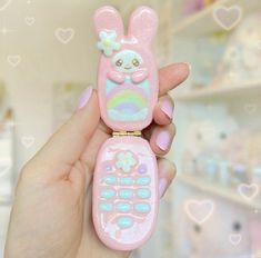 a hand holding a cell phone shaped like a bunny