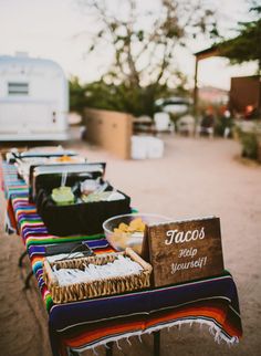 a row of tables that have food on top of each other in front of a trailer