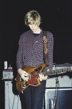 a young man is playing an electric guitar