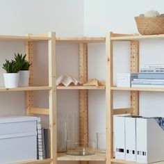 some shelves with books and other items on top of them in front of a white wall