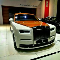 a rolls royce car is on display at a showroom with other cars in the background