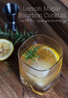 lemon maple bourbon cocktail with rosemary garnish in a glass on a wooden table