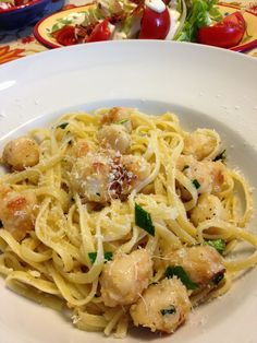 a white plate topped with pasta and shrimp