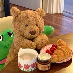 a teddy bear sitting at a table with some food