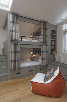 a bedroom with bunk beds and couches in the corner, along with built - in bookshelves