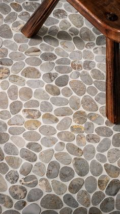 a wooden bench sitting on top of a stone floor