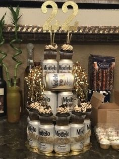 there is a cake made out of cans and cupcakes with candles on top