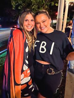 two women standing next to each other at night