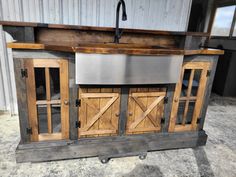 an outdoor kitchen made out of wood and metal with sliding doors on the outside wall