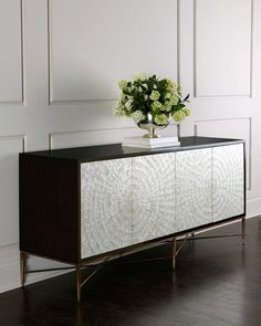 a white and black sideboard with flowers on top