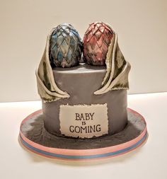 there is a cake that has two cakes on top of it and the words baby is coming