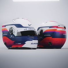 two racing helmets sitting side by side on top of each other