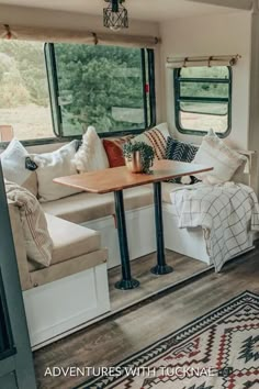 a living area with couches, tables and rugs in front of a window