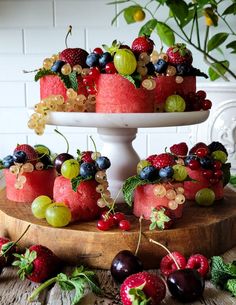 there is a cake with fruit on the top and berries on the bottom, along with other desserts