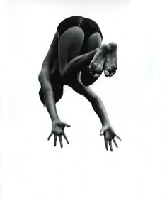 a black and white photo of a person diving