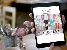 a person holding an ipad with the cover of chi omega