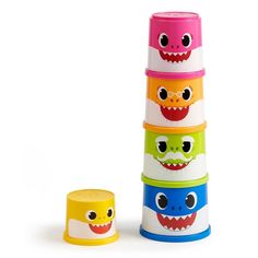 a stack of colorful cups with eyes and mouths on the top one has a smaller cup next to it