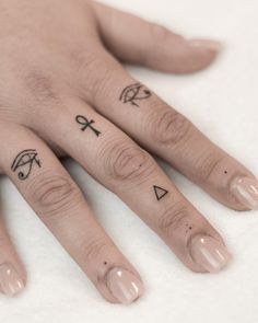 a person's hand with tattoos on it, and two fingers that have crosses