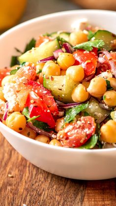 a white bowl filled with salad on top of a wooden table