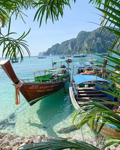 several boats are docked on the beach in clear water