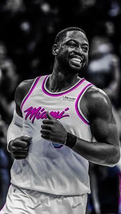 a black and white photo of a man running in a basketball game with the crowd watching