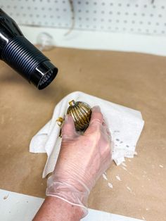 a person is using a hair dryer on a piece of paper with a shell in it