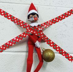 an elf is hanging on the wall with christmas decorations