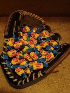 a heart shaped box filled with candy on top of a floor next to a wall