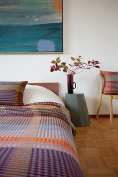 a bed sitting next to a painting on the wall