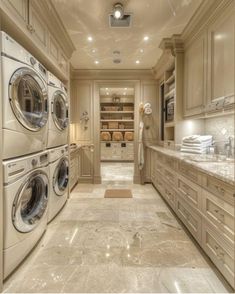 a large laundry room with washers and dryer in the center, cabinets on both sides