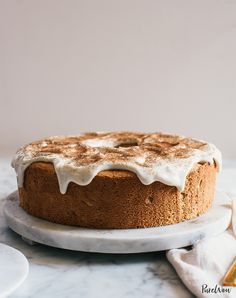 a cake sitting on top of a white plate covered in icing and cinnamon sugar