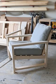 a wooden chair sitting on top of a hard wood floor next to a table with tools