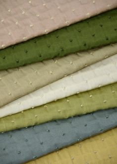 many different colored fabrics are stacked together