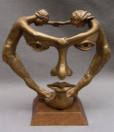 a bronze sculpture of two people holding each other's hands with their faces in the air