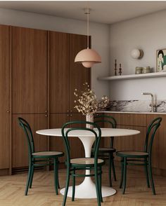 a white table with four green chairs around it