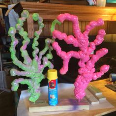 two fake corals sitting on top of a table next to a spray paint can