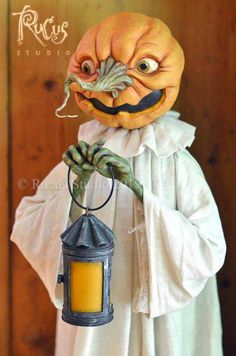 a pumpkin dressed as a man holding a lantern