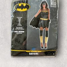 the batman costume is on display in its plastic package, which includes a batgirl mask and gloves