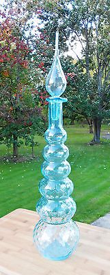 a blue glass vase sitting on top of a wooden table