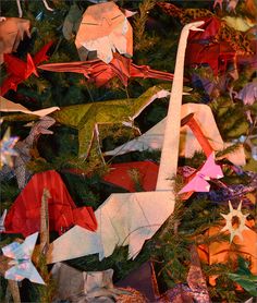 an assortment of origami birds hanging from a christmas tree