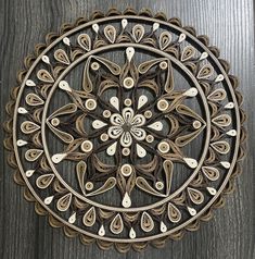 an intricately designed wooden wall hanging on a wood paneled wall with white and brown accents