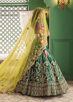 Blue Green Bridal Lehenga Choli for Indian Bridal Wear is pure raw silk pure lehnga in emerald green is hand-rendered in gold and is enhanced with naqshi, Sitara, and dabka and leather motifs. The ink blue raw silk choli has gorgeous Suzanne motifs with Sitara work and is paired with a yellow net dupatta that is framed with an aari border and Kiran. The stunning yellow veil with aari work, pearls, and Sitara is the star of the show. Choli: Glamour meets opulence in this ethereal cappuccino and g Green Tissue Silk Choli With Intricate Embroidery, Green Silk Lehenga With Pallu Detail, Green Lehenga With Pallu In Silk, Green Silk Lehenga With Pallu, Festive Green Lehenga With Sheer Dupatta, Green Art Silk Anarkali Set With Intricate Embroidery, Green Raw Silk Choli With Intricate Embroidery, Green Art Silk Choli With Intricate Embroidery, Green Dola Silk Sharara For Reception