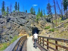 two people riding bikes on a wooden bridge