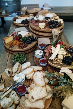 several wooden trays filled with different types of cheese and bread on top of a table