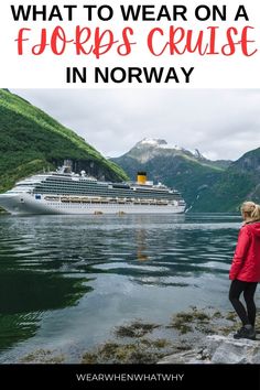 a woman standing on rocks looking at a cruise ship in norway