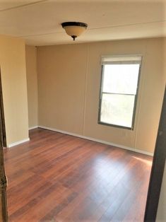 an empty living room with hard wood floors and no one in the house or furniture