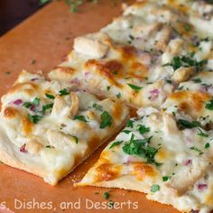 a pizza with chicken and cheese is cut into slices