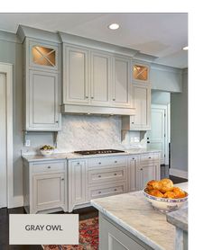 a large kitchen with white cabinets and marble counter tops