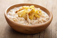 a wooden bowl filled with oatmeal and bananas